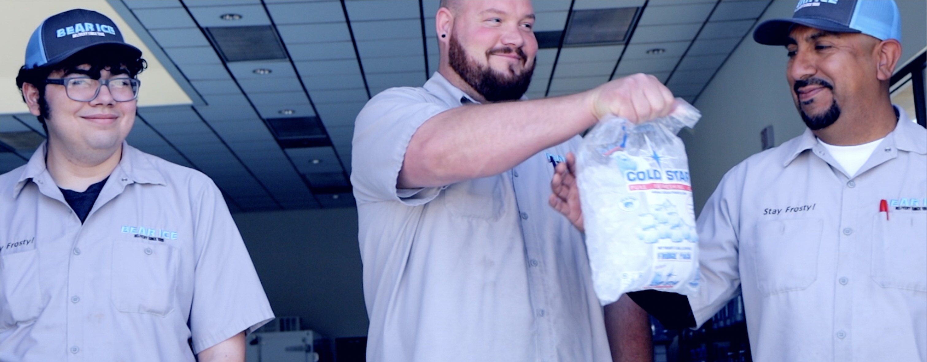 Documentary portrait workers wearing company caps passing a small ice bag