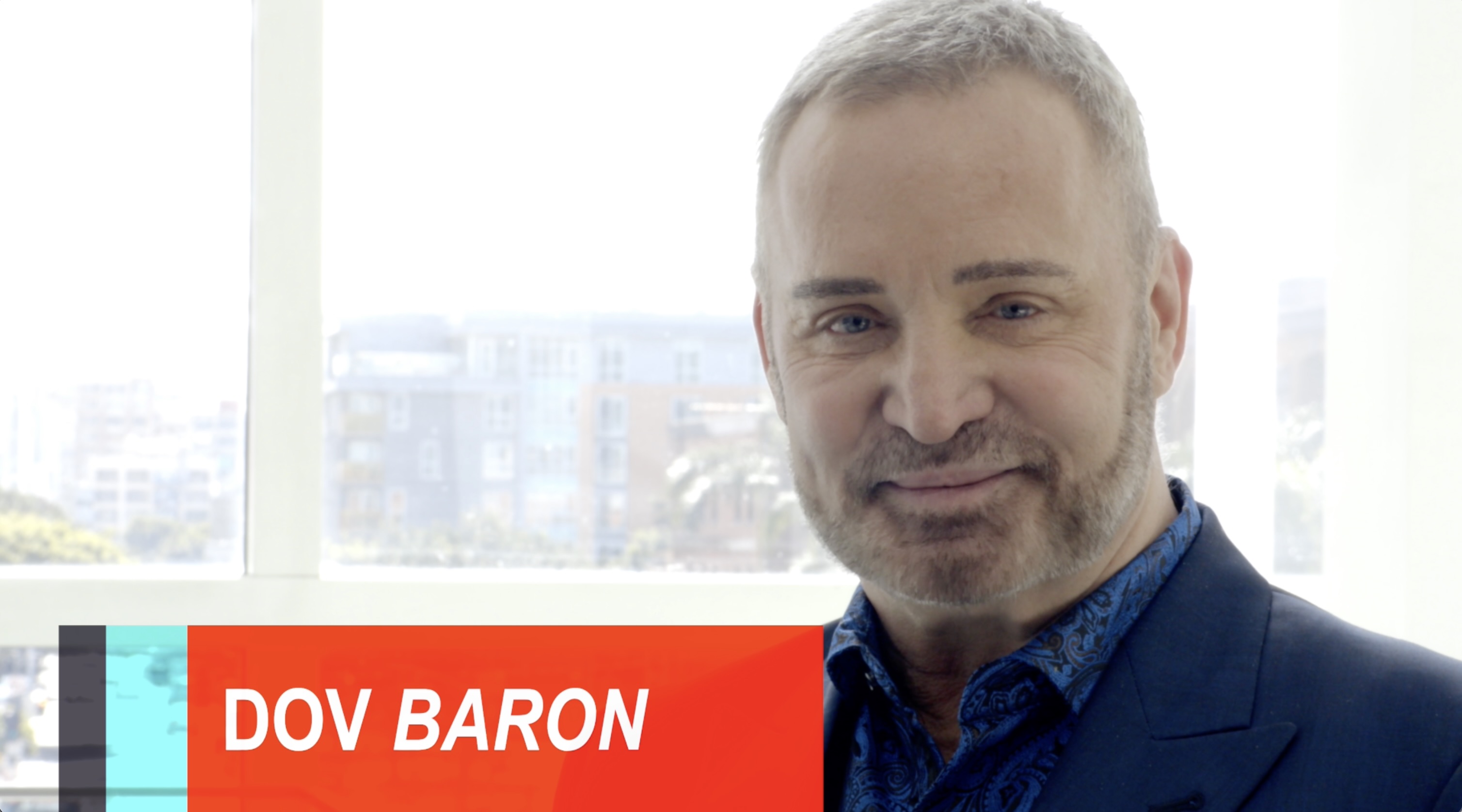 Professional portrait of speaker smiling against bright window