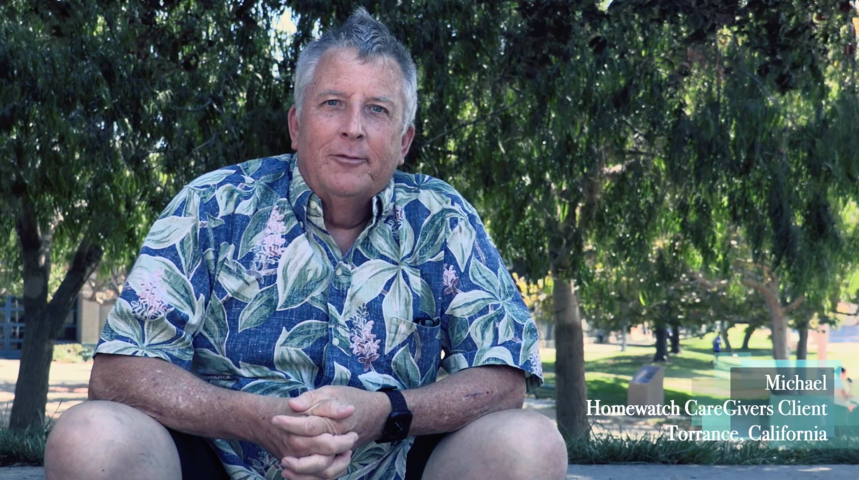Outdoor documentary portrait of man speaking beneath trees