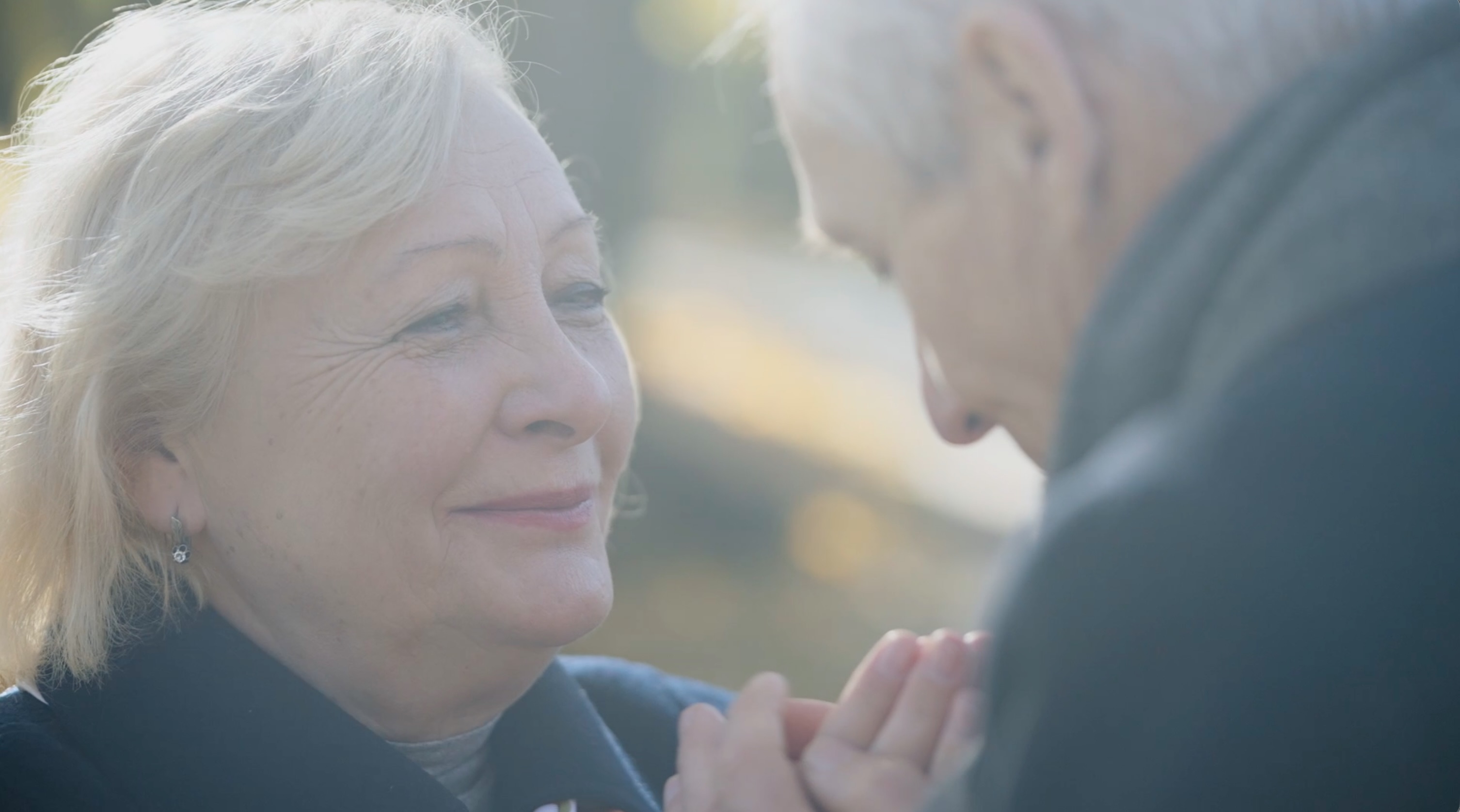 Soft-focus emotional close-up between elderly couple in warm light