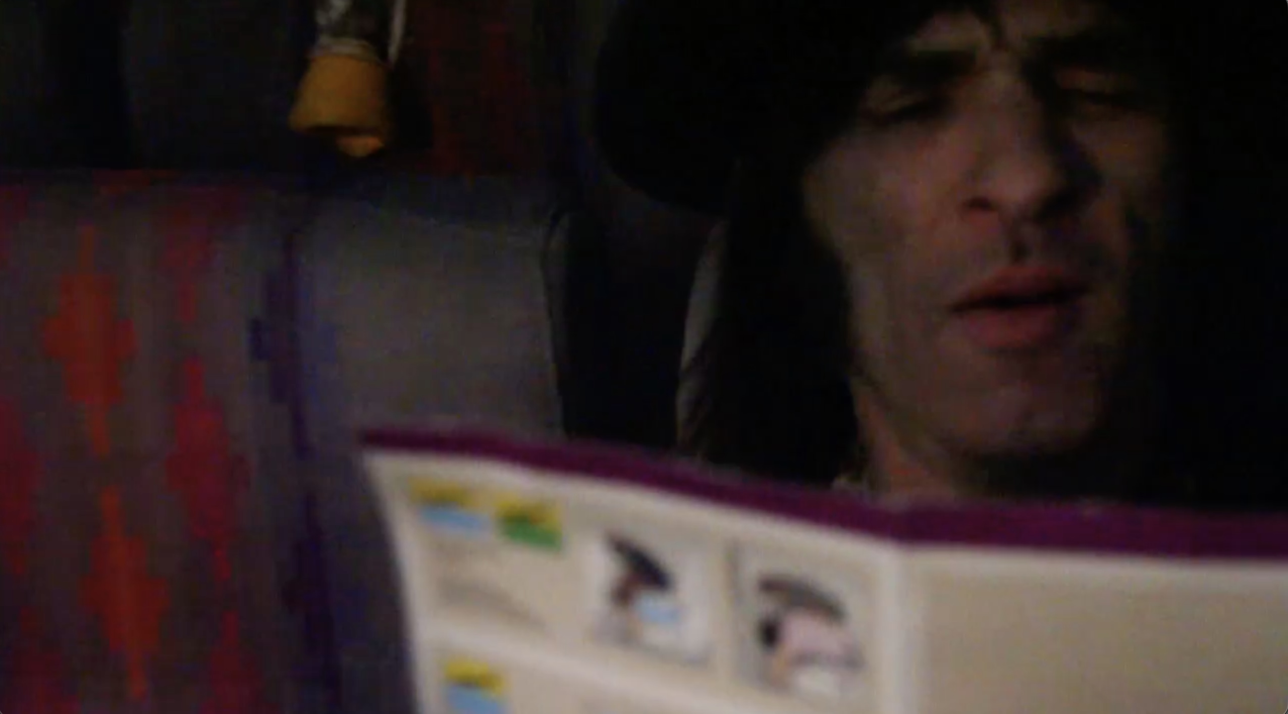 Moody close-up portrait of dark-haired man reading airplane emergency guide on jet plane with oxygen masks in background