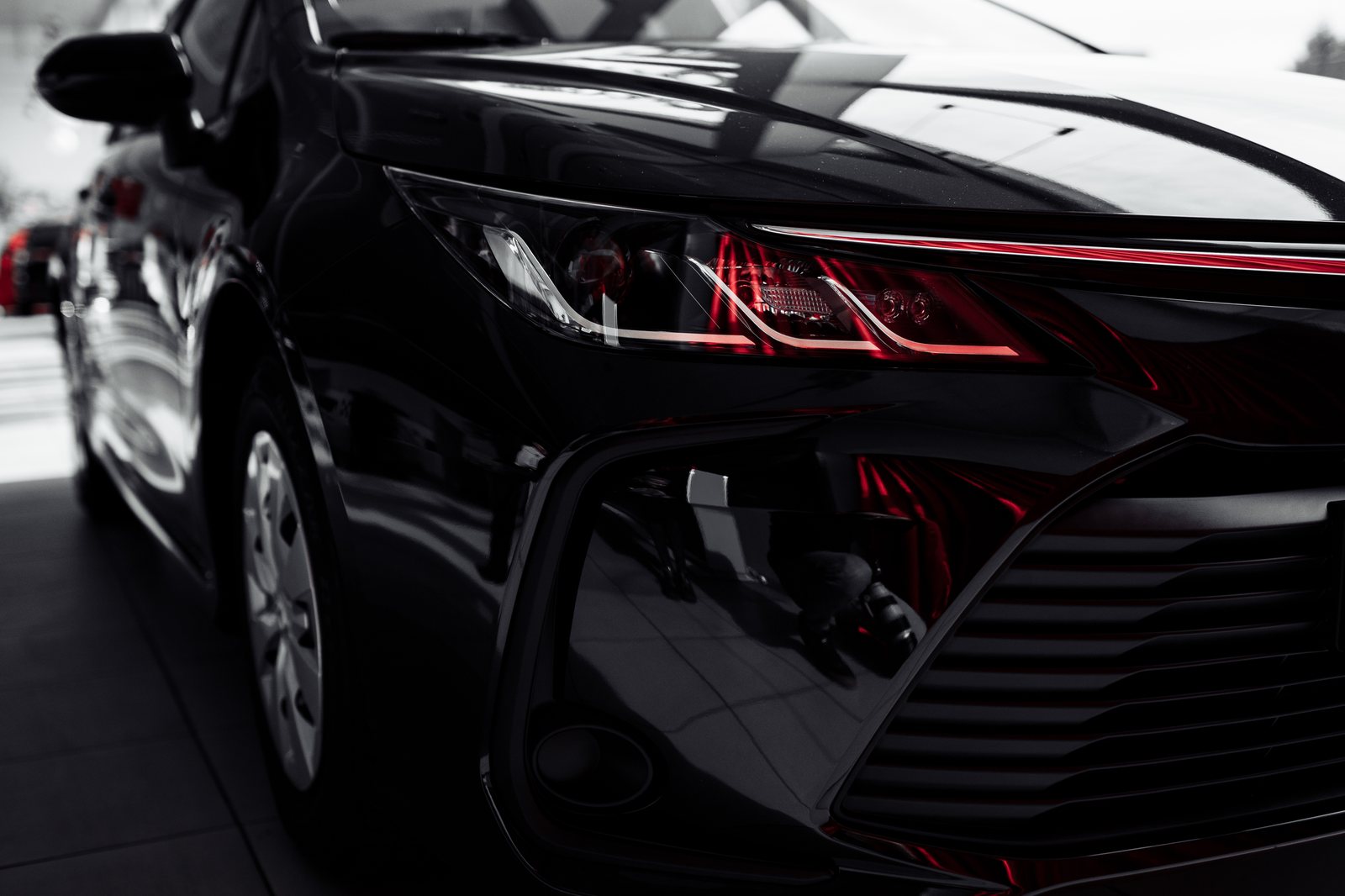 A glossy black car detailed in moody light