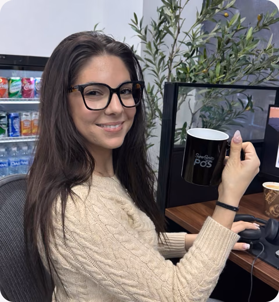 SuperSonic support specialist at the Tampa office holding a SuperSonic mug