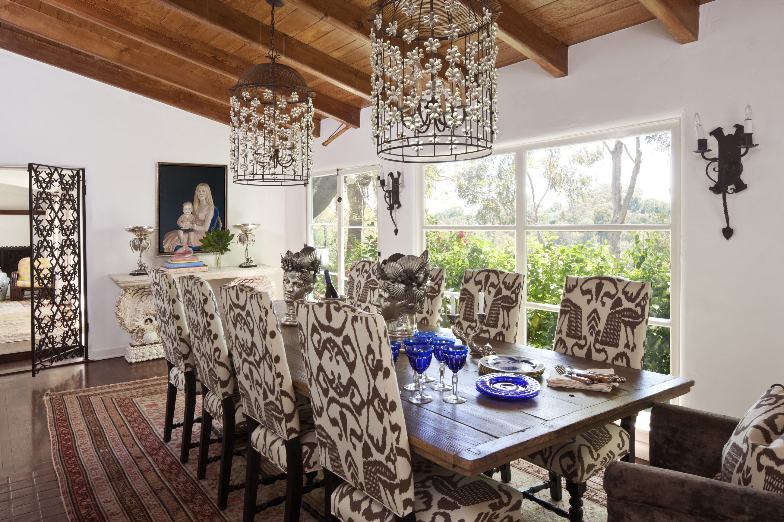 Beamed dining room with ikat chairs and beaded chandeliers