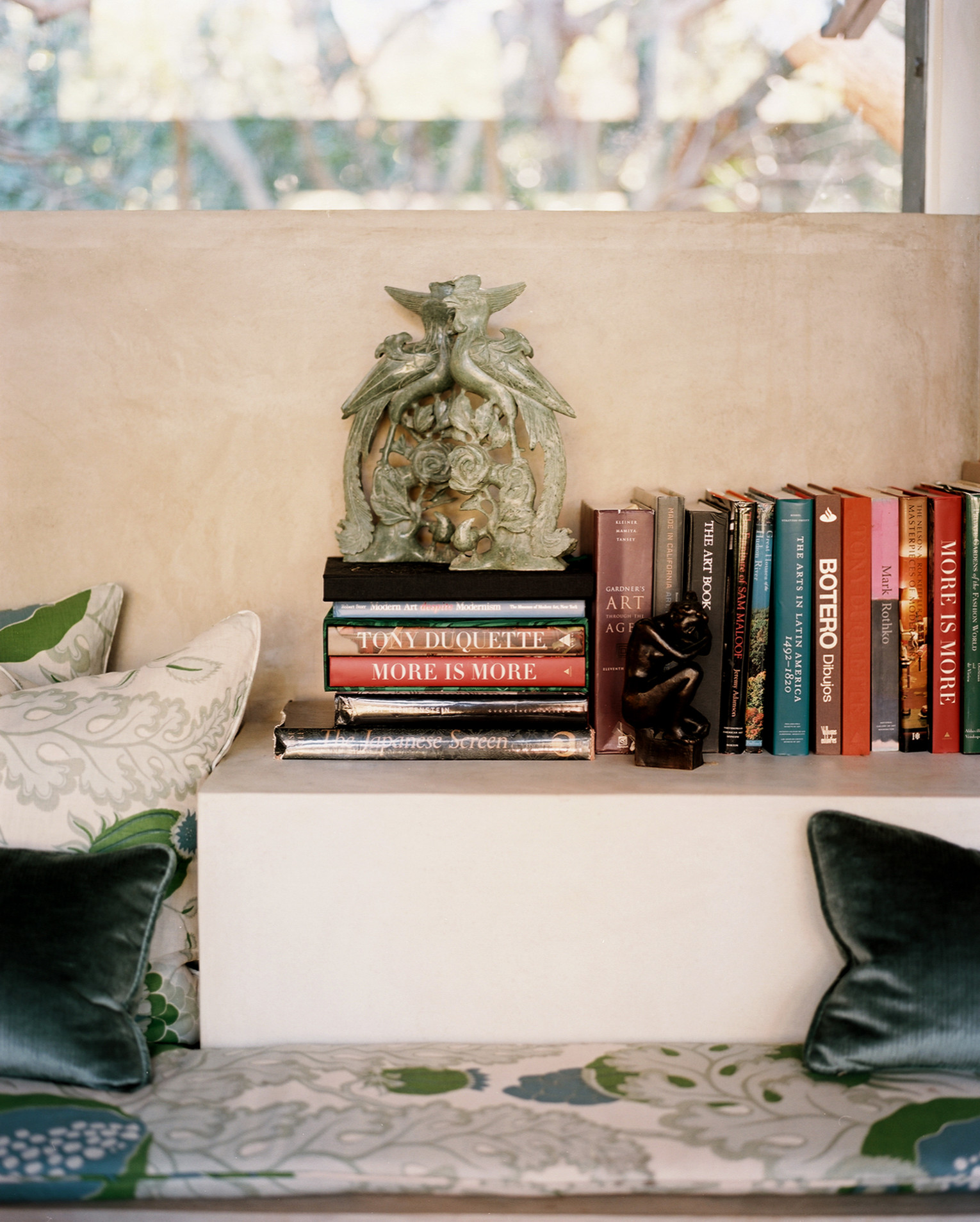 Midcentury Modern Retreat banquette ledge with art books by Hillary Thomas