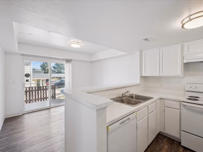 Kitchen with white cabinets and white appliances and view of living room