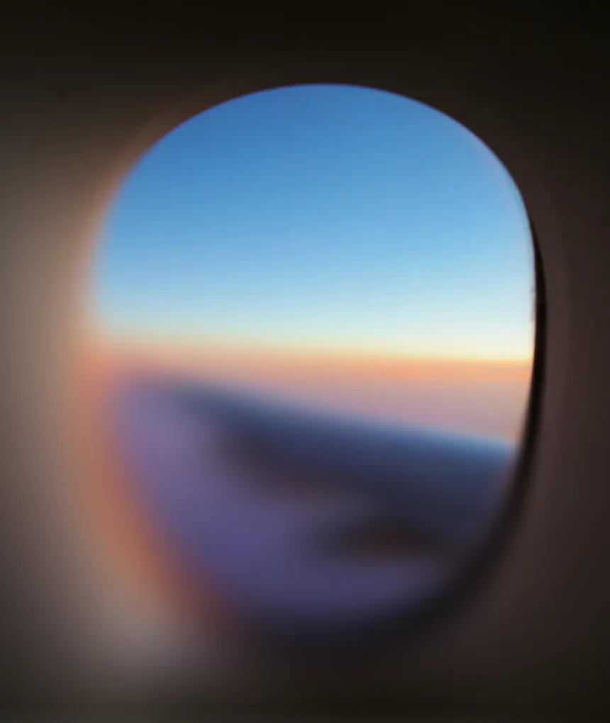 Blurry view of airplane wing from plane window