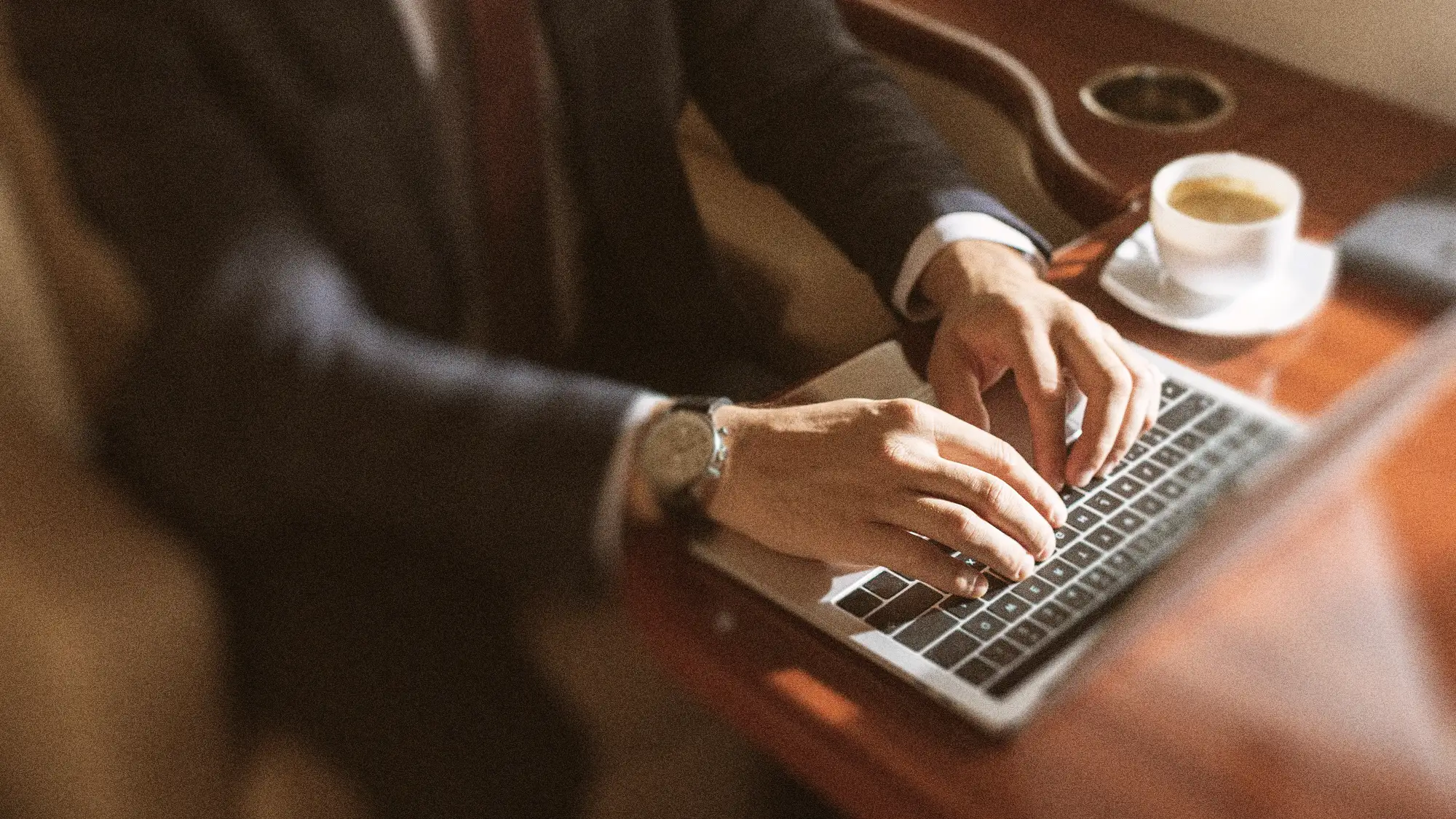 Man typing on computer on a private jet.