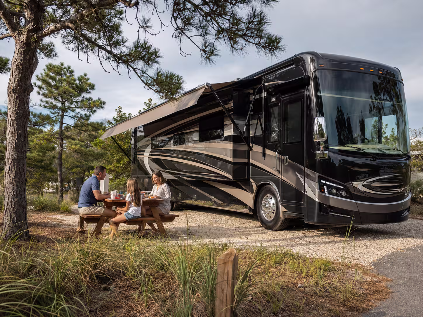 Luxury motorhome set up at an Outer Banks campground with a family outside