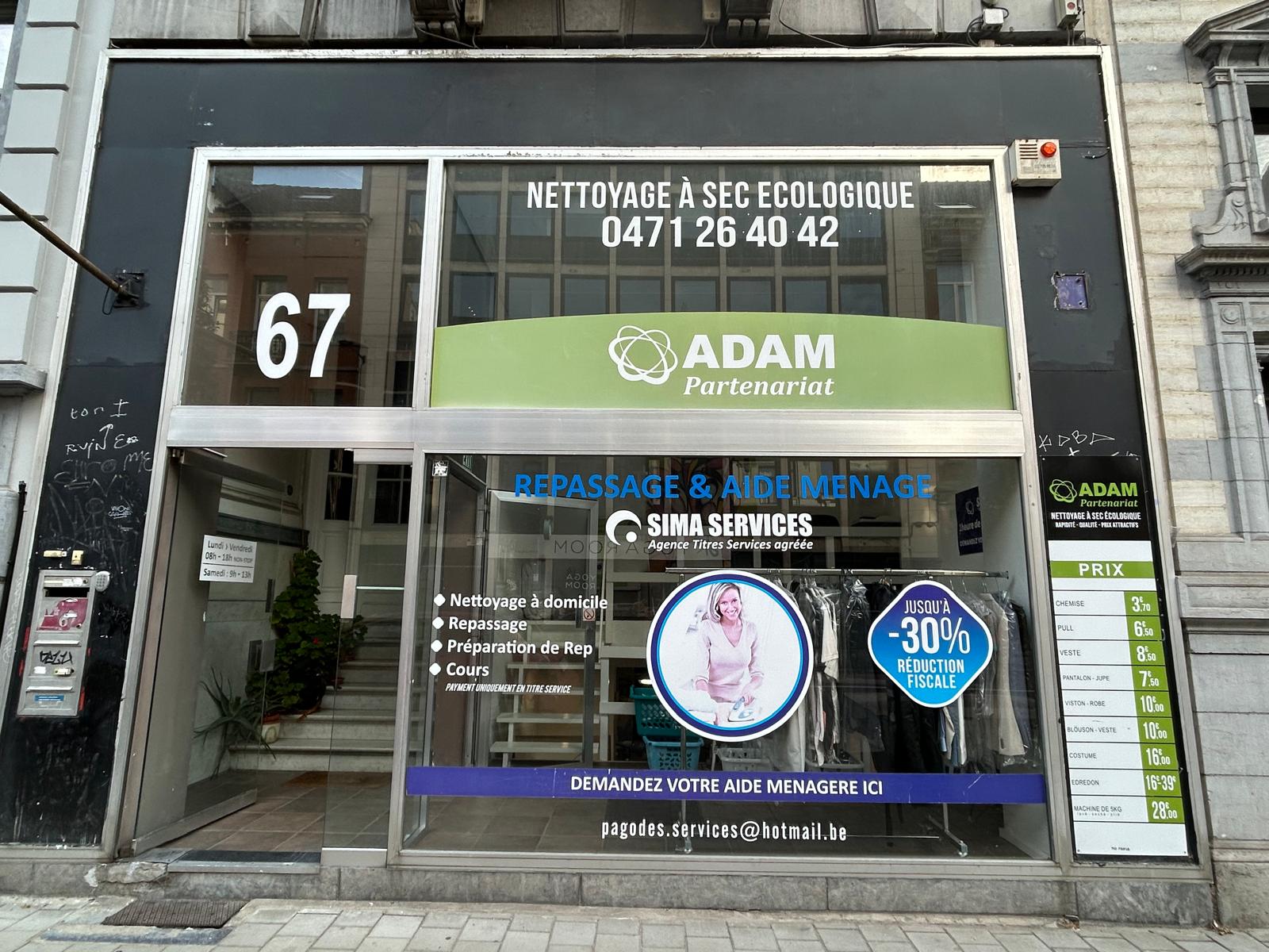 Devanture d'une boutique de vêtements élégante avec une femme examinant un vêtement à l'intérieur.
