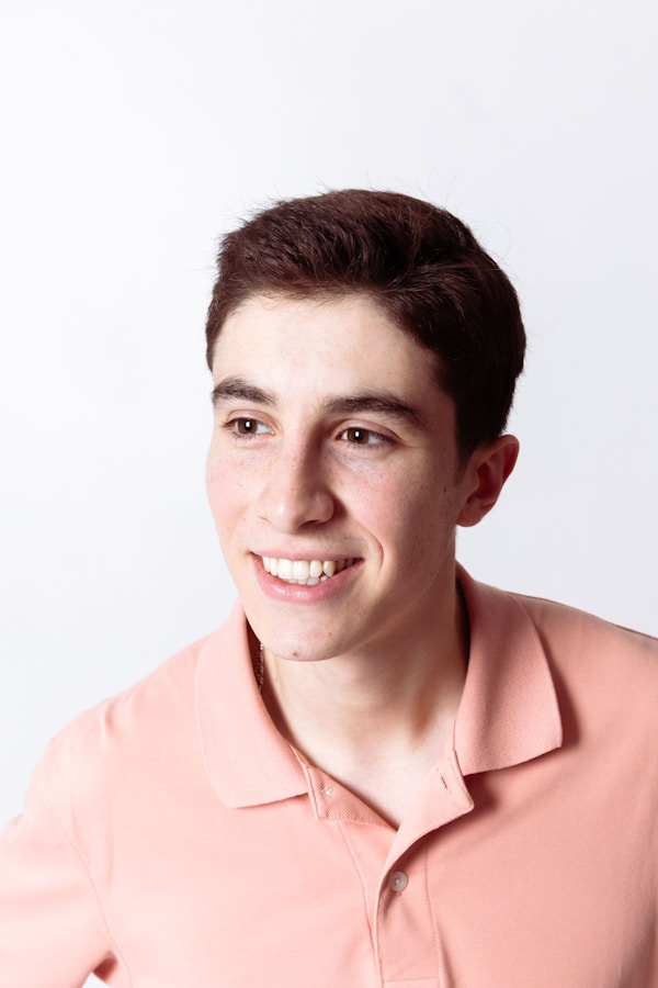 Young man in a peach polo shirt smiling