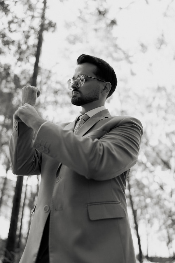 Man in suit adjusting cuff in forest