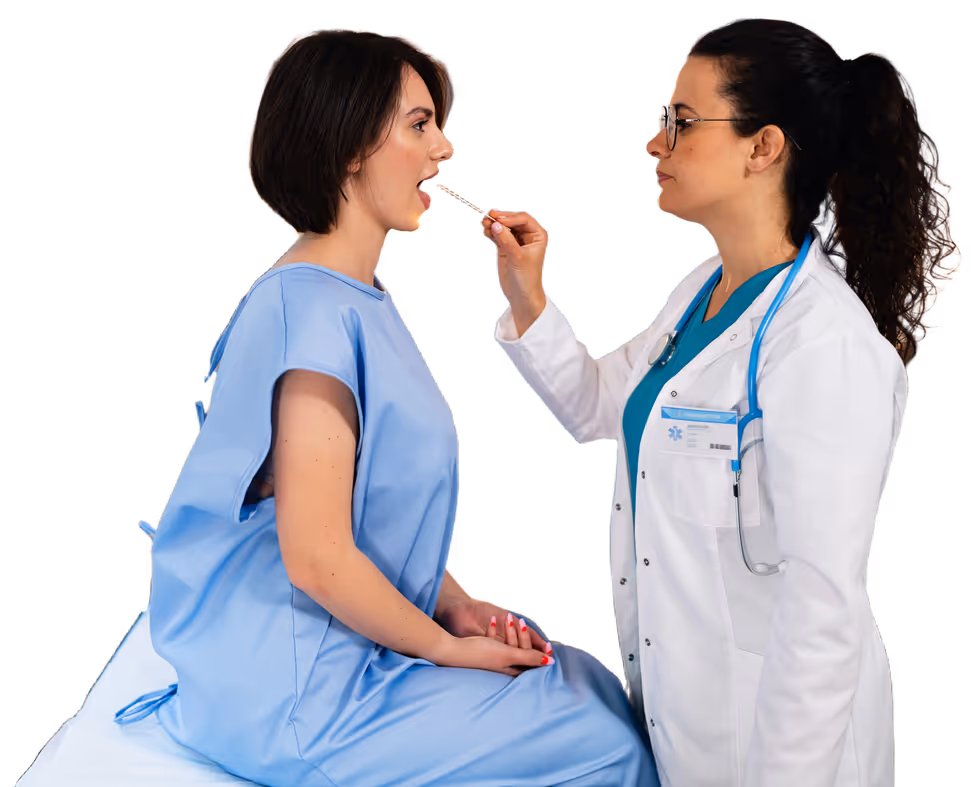 Doctor in white coat and stethoscope examining patient’s throat with tongue depressor.