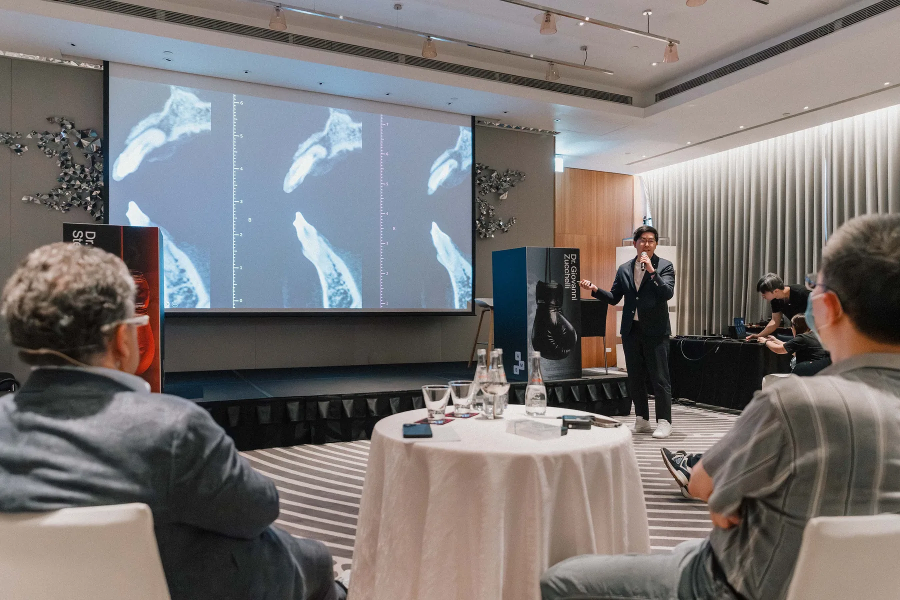 An instructor explains clinical techniques using projected images