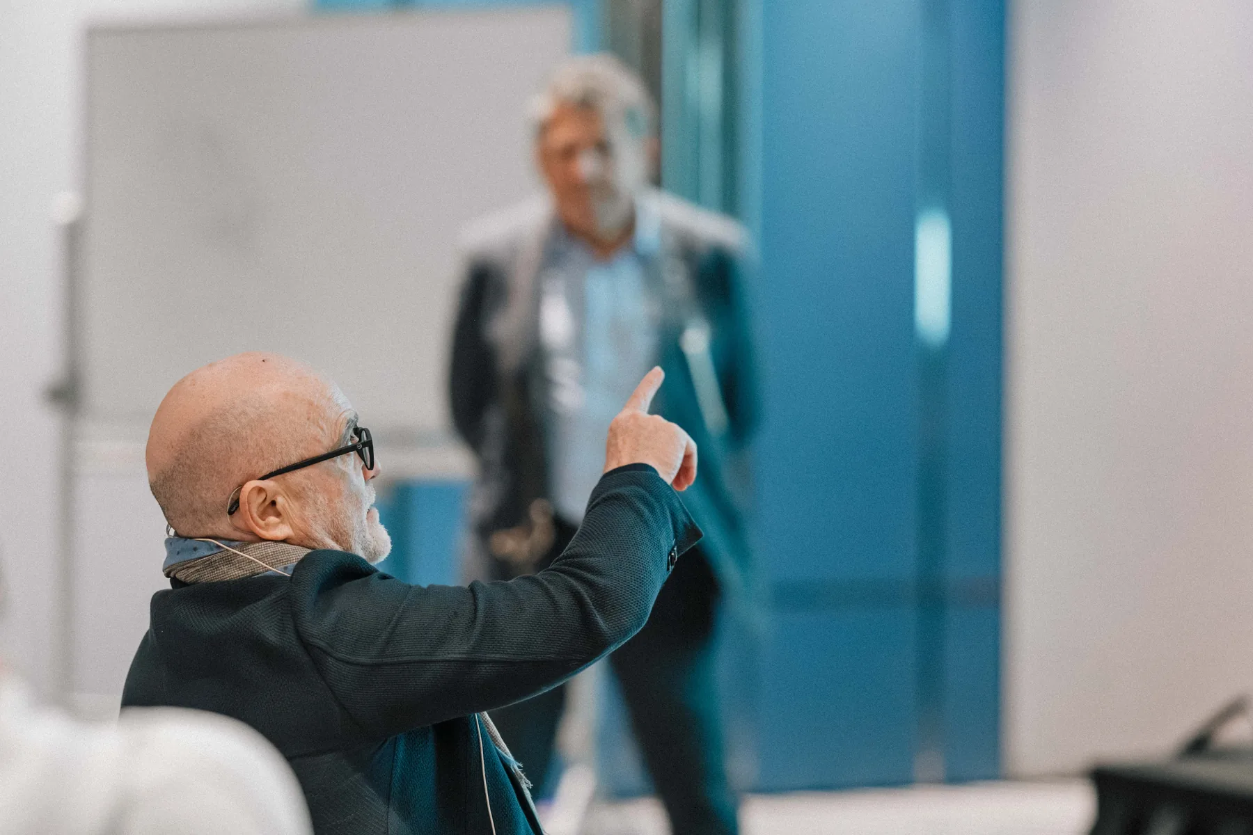 A participant raises a hand during a course discussion