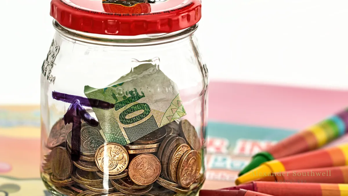 Glass savings jar full of coins and notes, saving for a first time buyer deposit