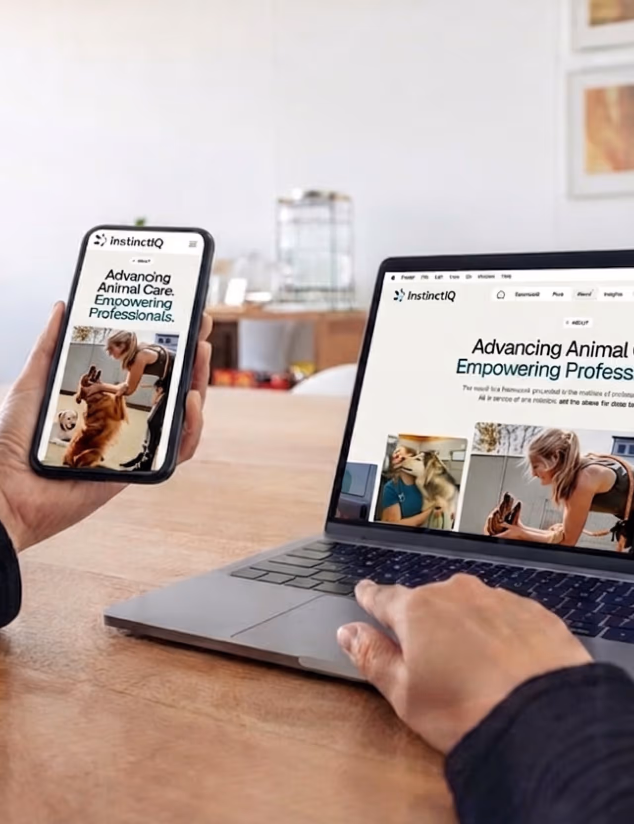 Person holding phone and using laptop showing InstinctIQ website about advancing animal care and empowering professionals.