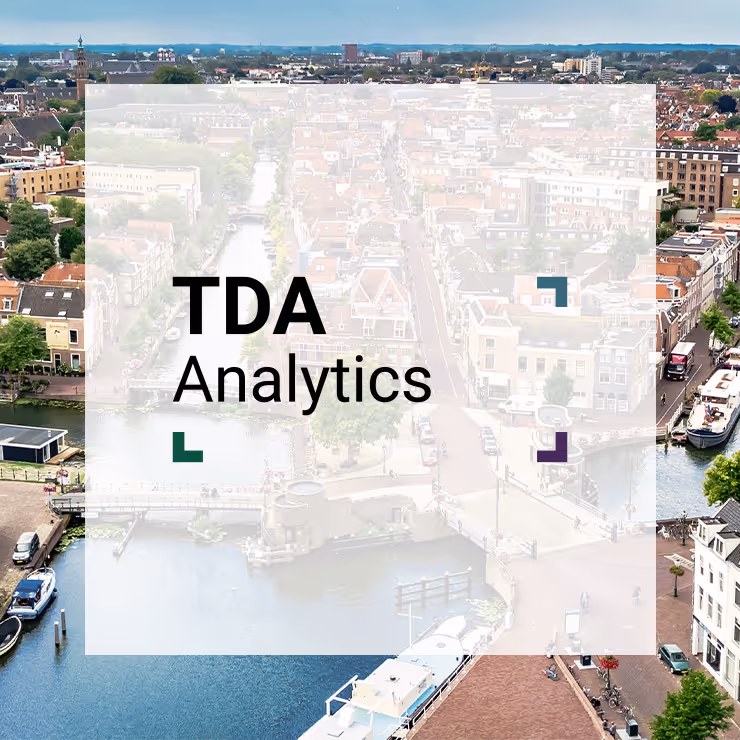 Cityscape with canal and streets overlaid with a white transparent square containing the text 'TDA Analytics'.