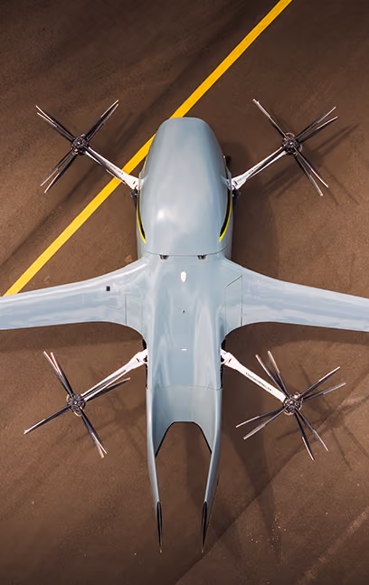 Top view of a modern electric drone aircraft with four propellers on a runway with a yellow line.