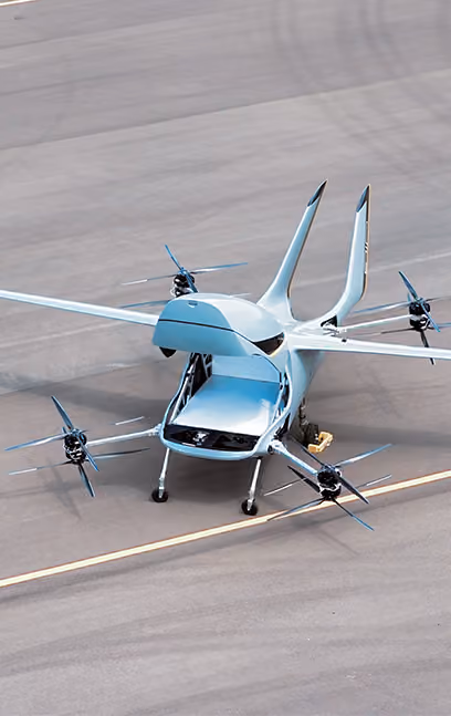 Futuristic drone-like aircraft with an open storage compartment on an airstrip.