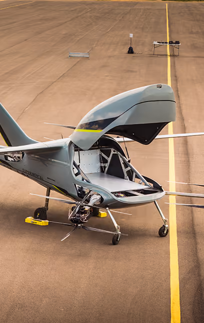 Small gray aircraft on runway with front nose cone open and exposed interior components.