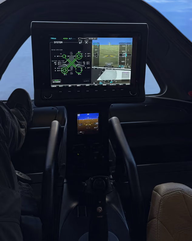 Cockpit view showing flight instruments and controls with clear sky outside the aircraft.