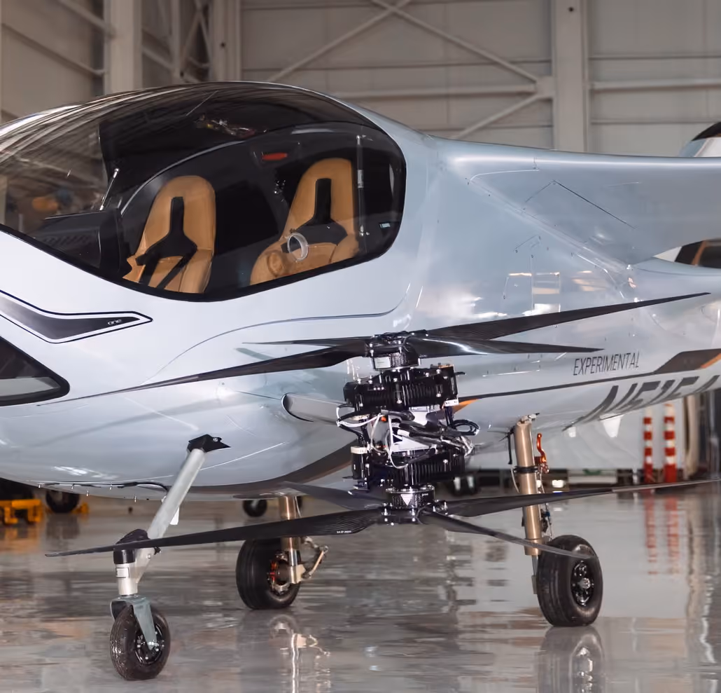 Small experimental aircraft with dual-seat cockpit and visible rotor propulsion system on front landing gear.
