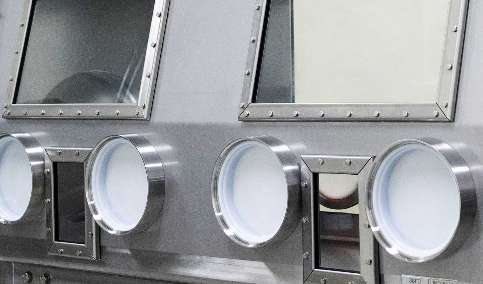 Stainless steel nuclear glovebox with multiple sealed access ports fabricated by Lindquist Machine Co.