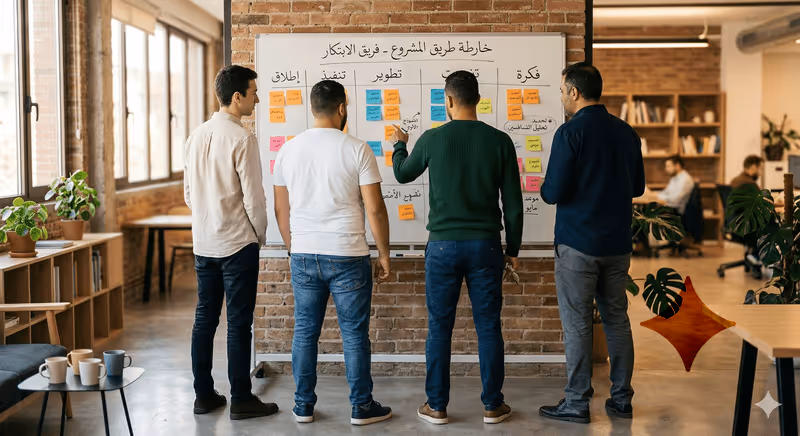 Quatre hommes debout devant un tableau blanc avec des notes adhésives dans un bureau moderne et lumineux.