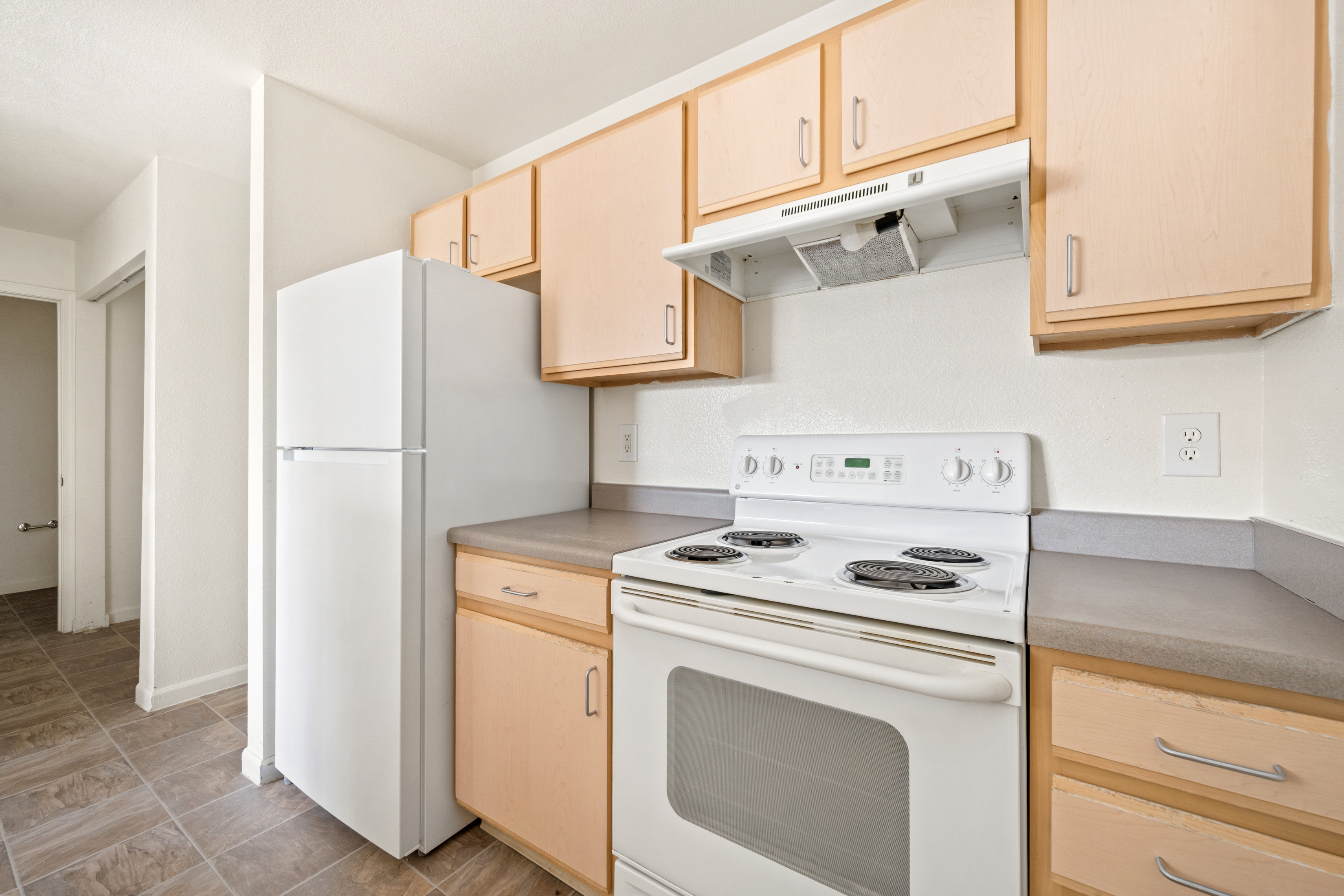 Kitchen with light wood cabinets and white appliances