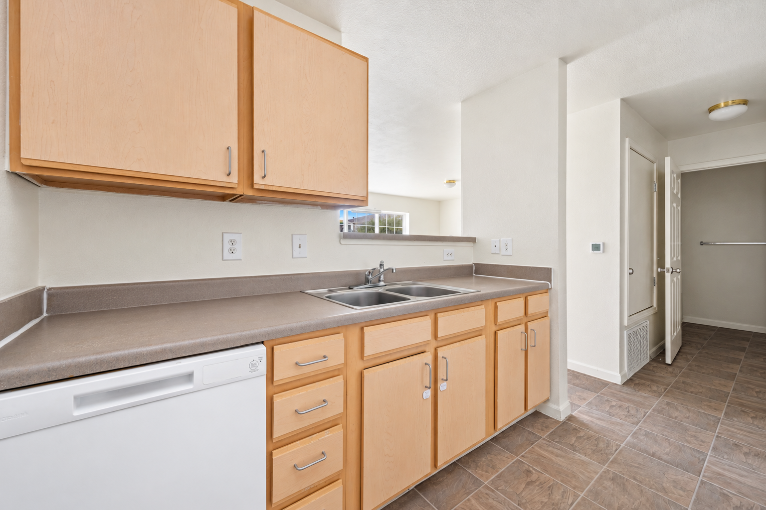 Kitchen with light wood cabinets and white appliances