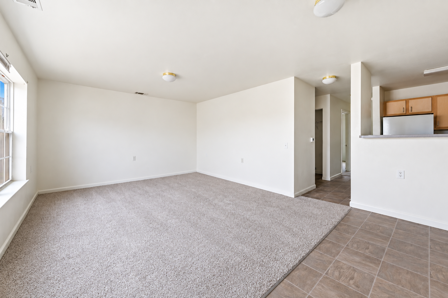 Living area unfurnished with view of kitchen