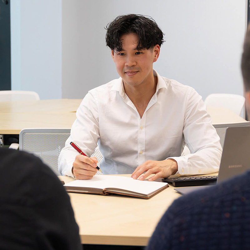 Liam taking notes in a meeting