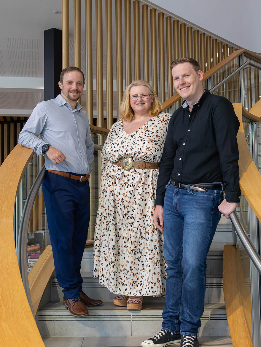 The leadership team smiling on the stairs