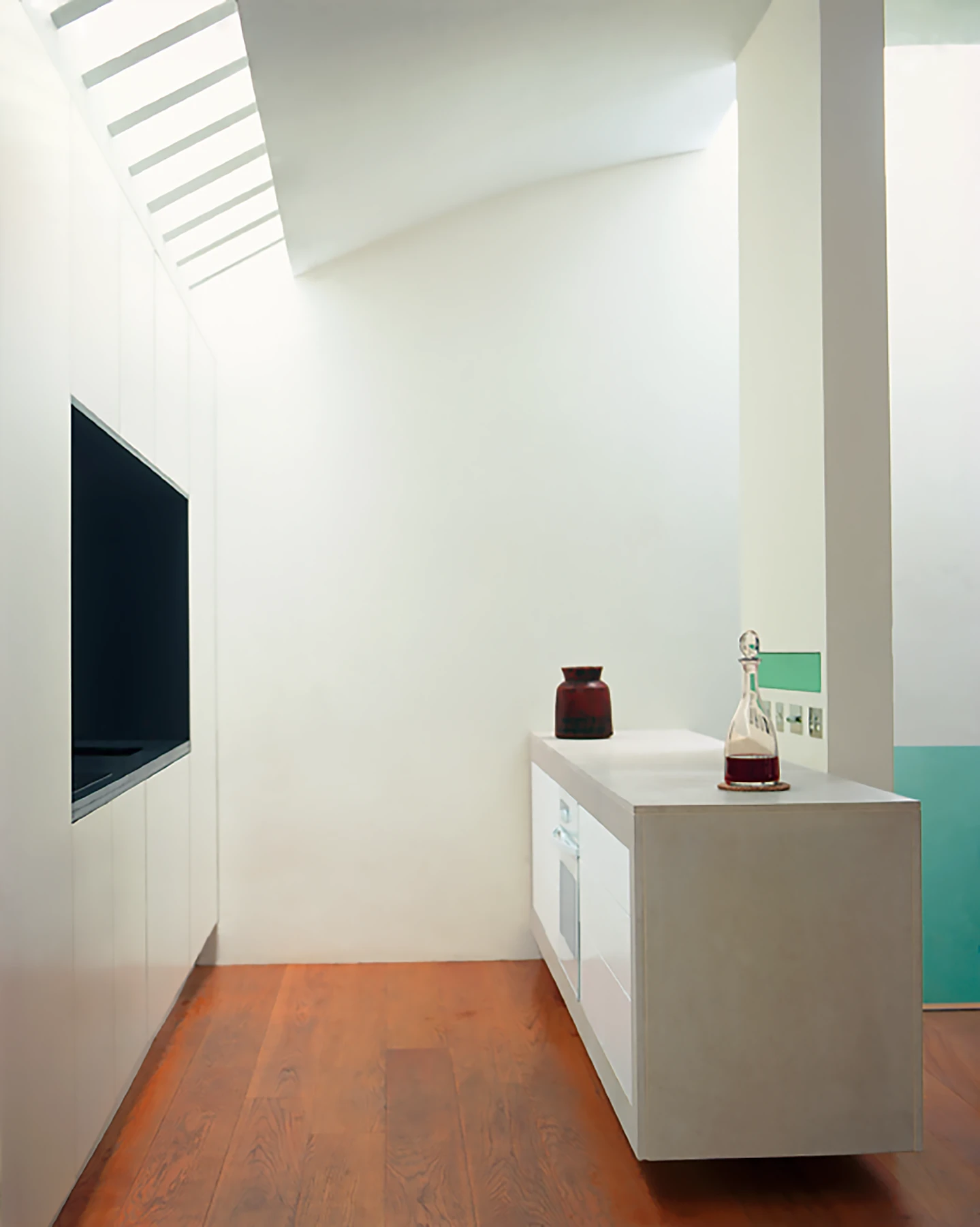 The kitchen island, a block of stone, appears to float.