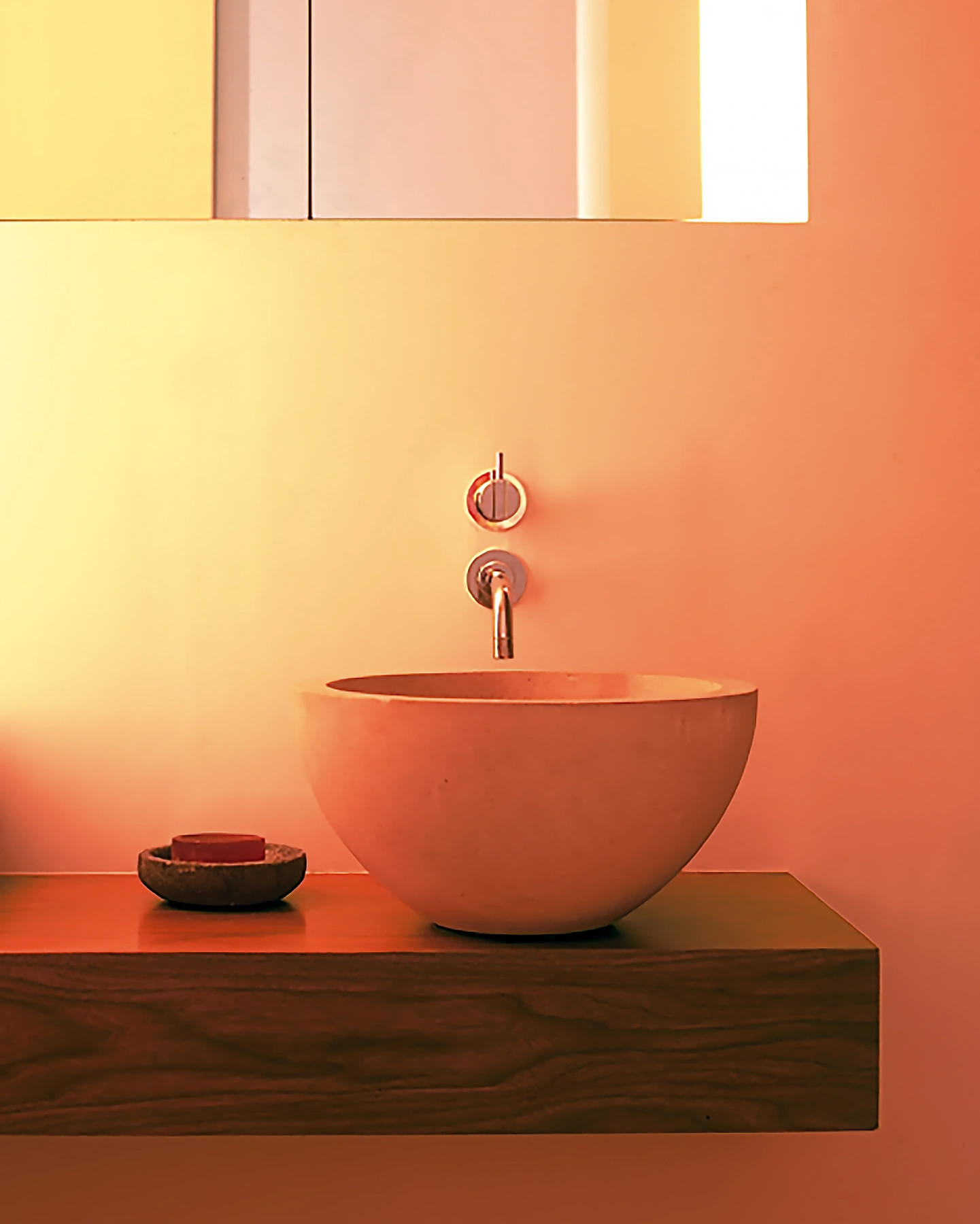The simple black oak bathroom with a hand-carved basin from the stone masons of Wells Cathedral. 