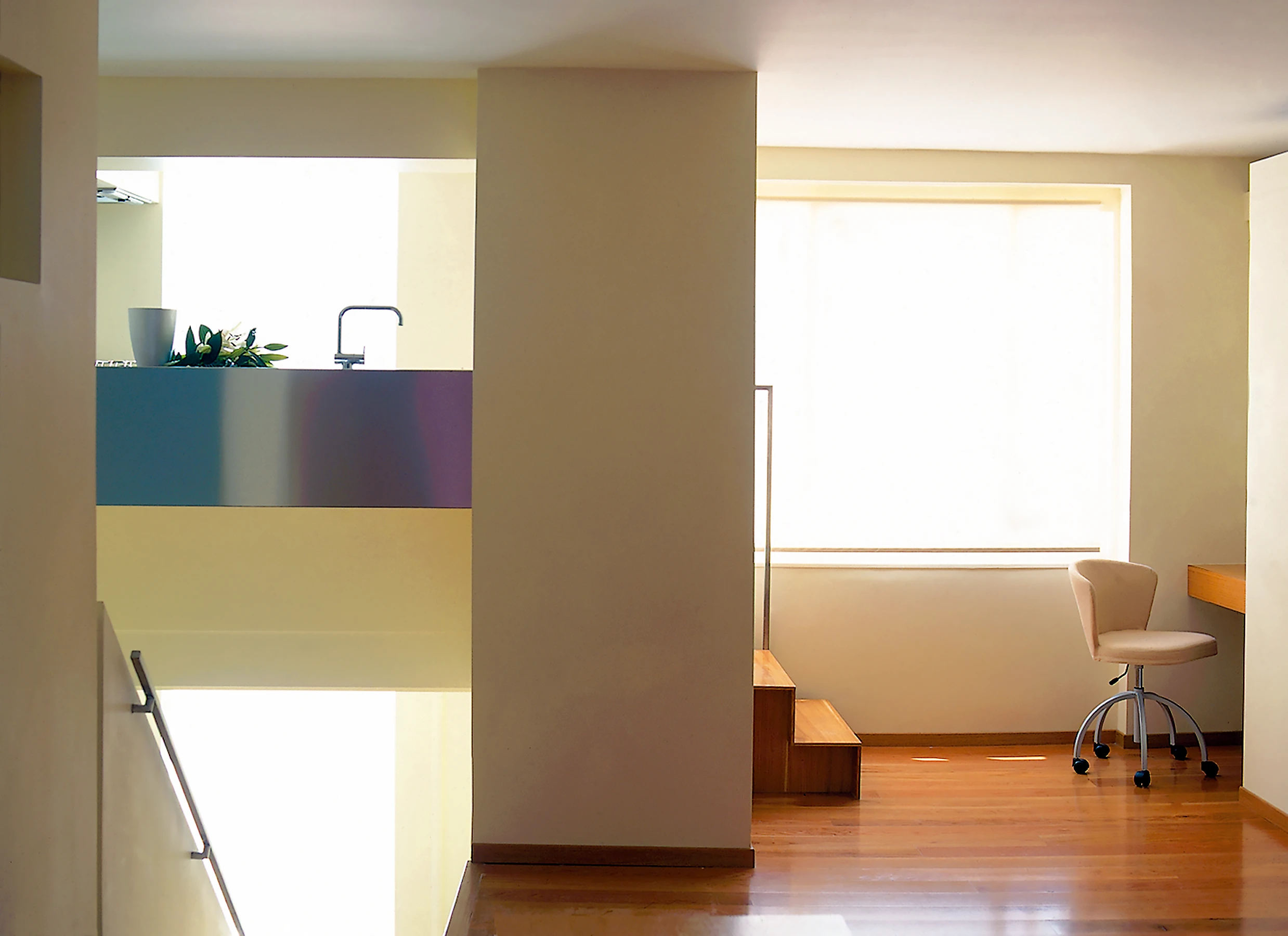 By purchasing the upper part of the common parts stair core, we were able to create a two and a half storey high entrance hall flooded with morning light. The space above the stairs allowed us to insert a micro kitchen a half level up, screened from view but with a view of the whole apartment. A study desk is revealed behind sliding panels. 