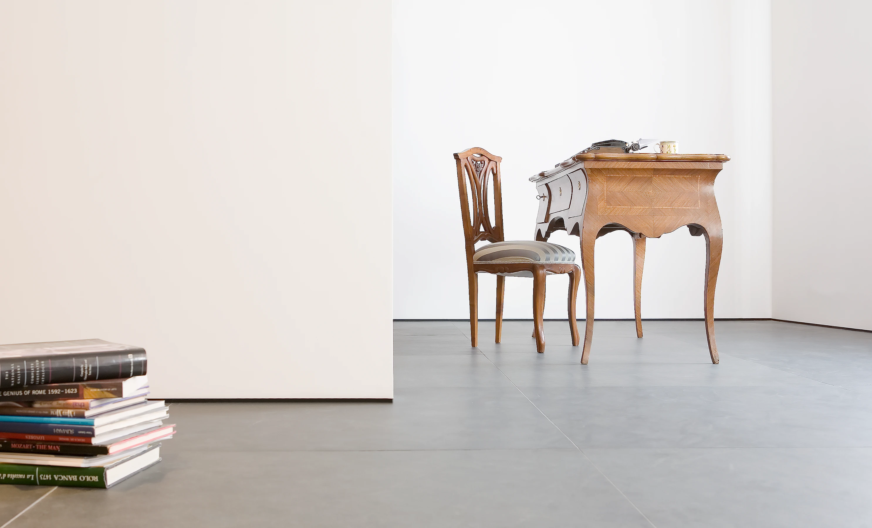 Walls float over a Pietra Serena stone floor, creating a contrast with antique furniture.