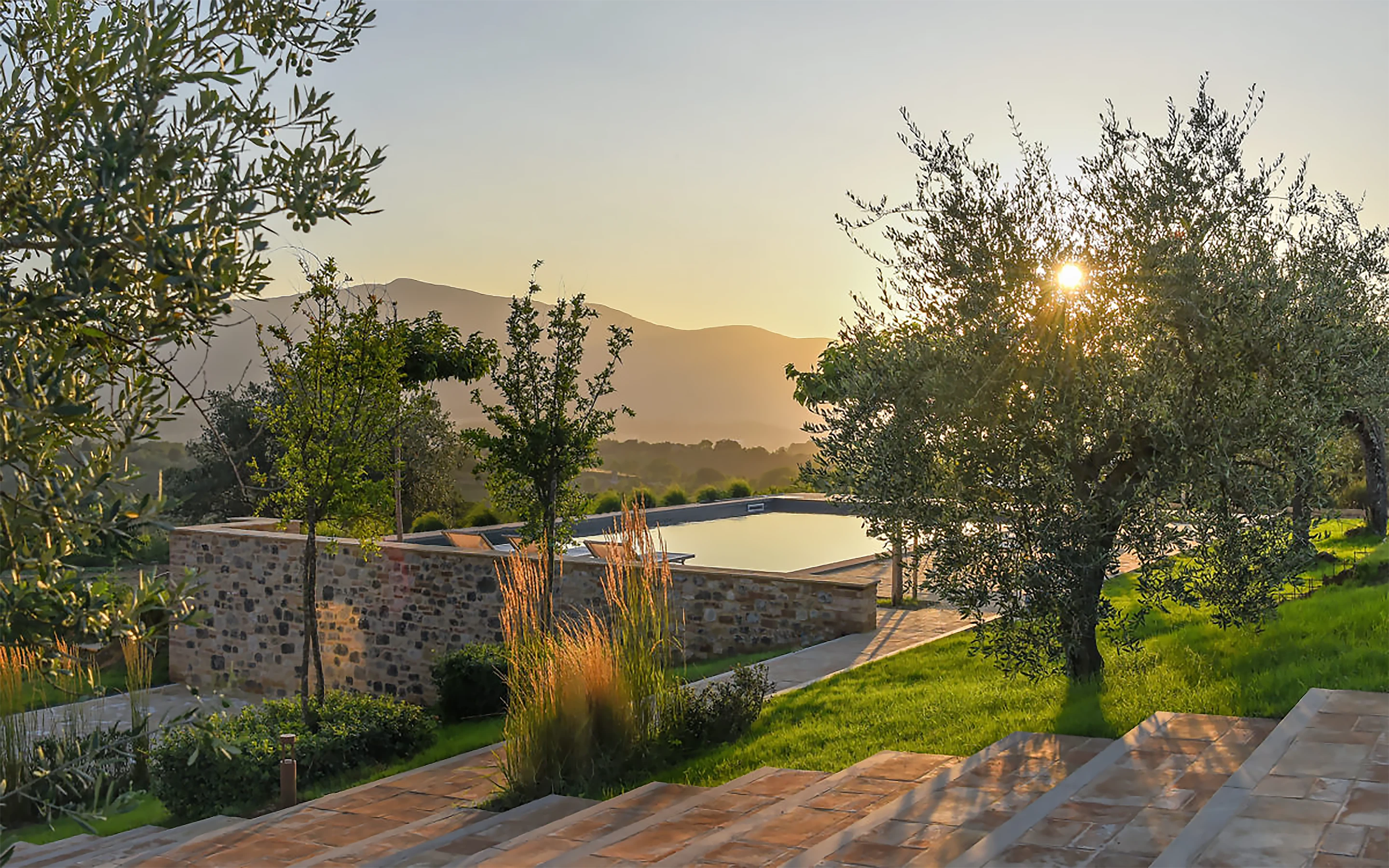 Terraces are formed to the north and south, and the principal barn elevation opens up to views down the mountain to the west. The pool sits discreetly below the northern terrace.