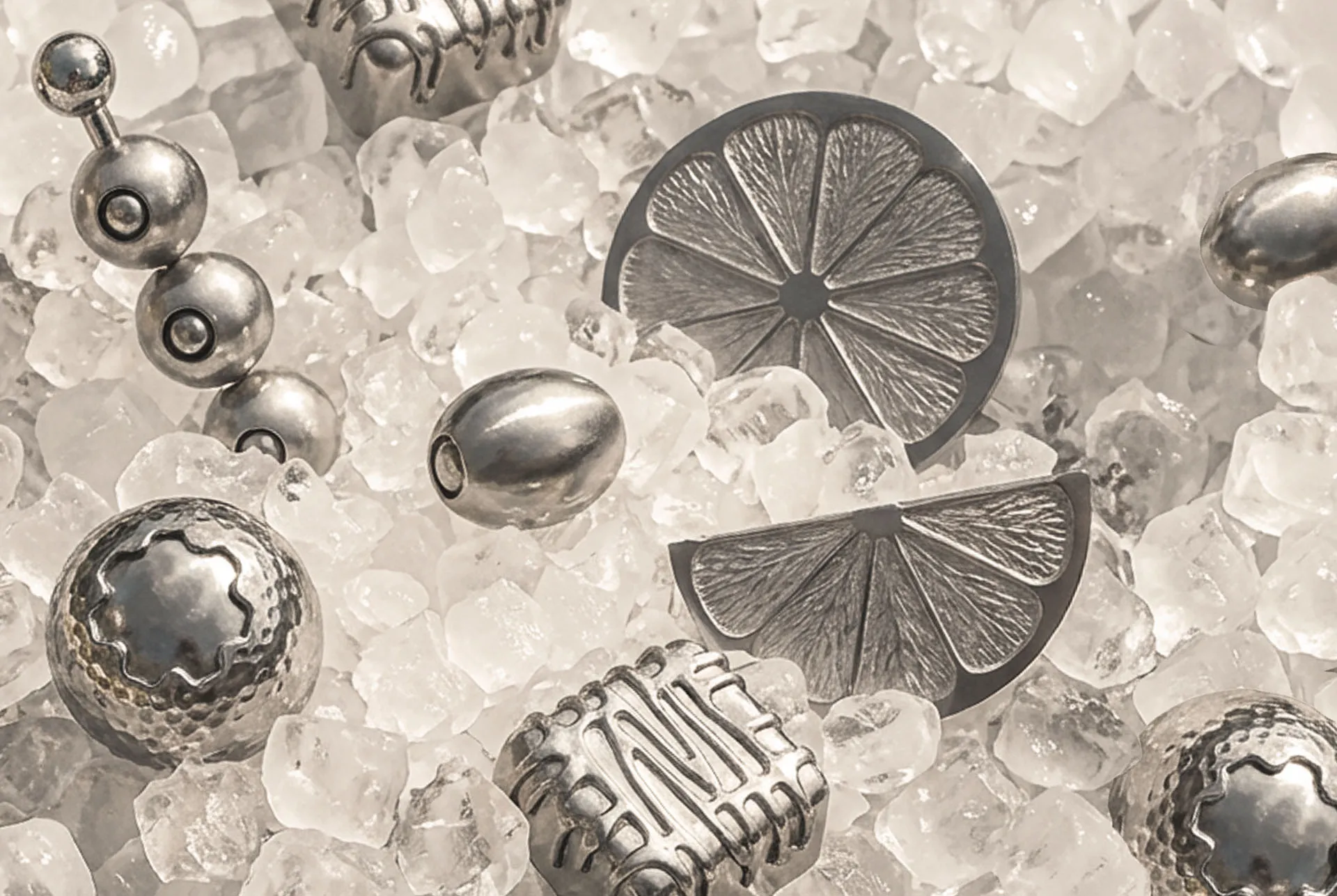 Gearbox titanium ice cubes cast as gears, sprockets and a gear cut citrus wheel, scattered over crushed ice