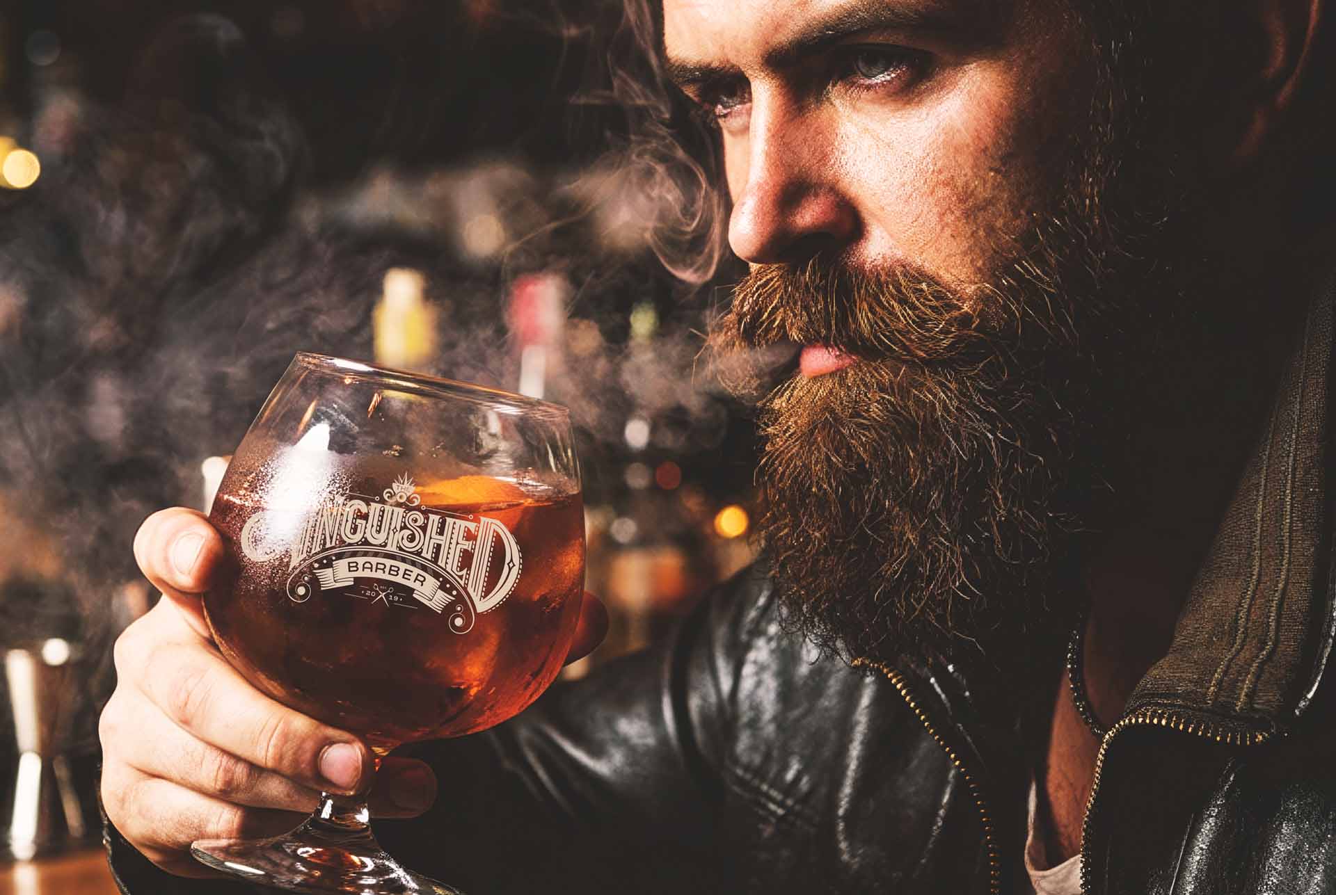 Bearded patron drinking from a branded Anguished Barber glass