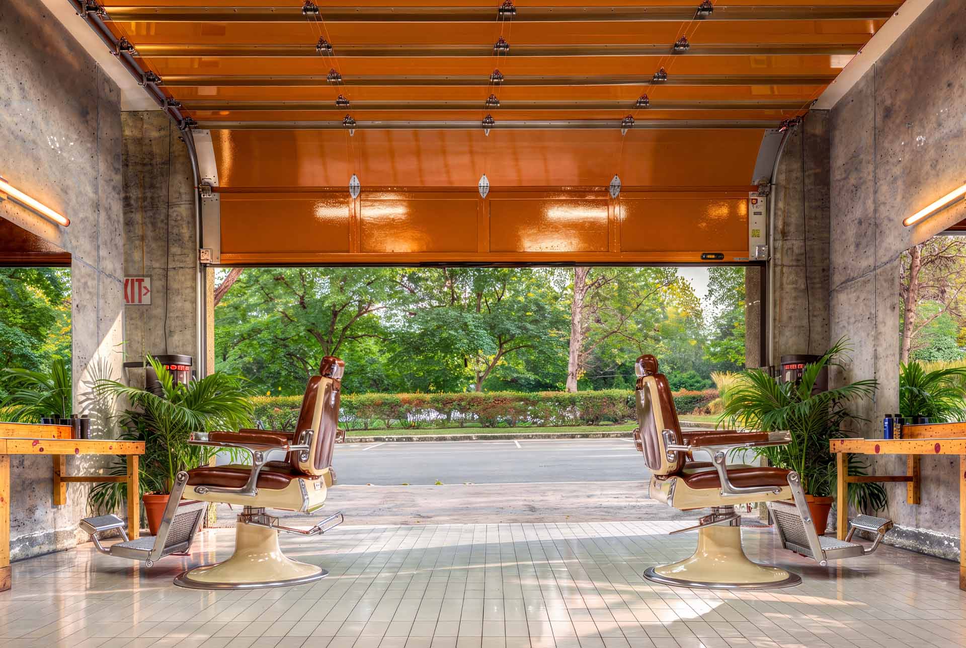 De León barbershop opening onto greenery through a roll up door