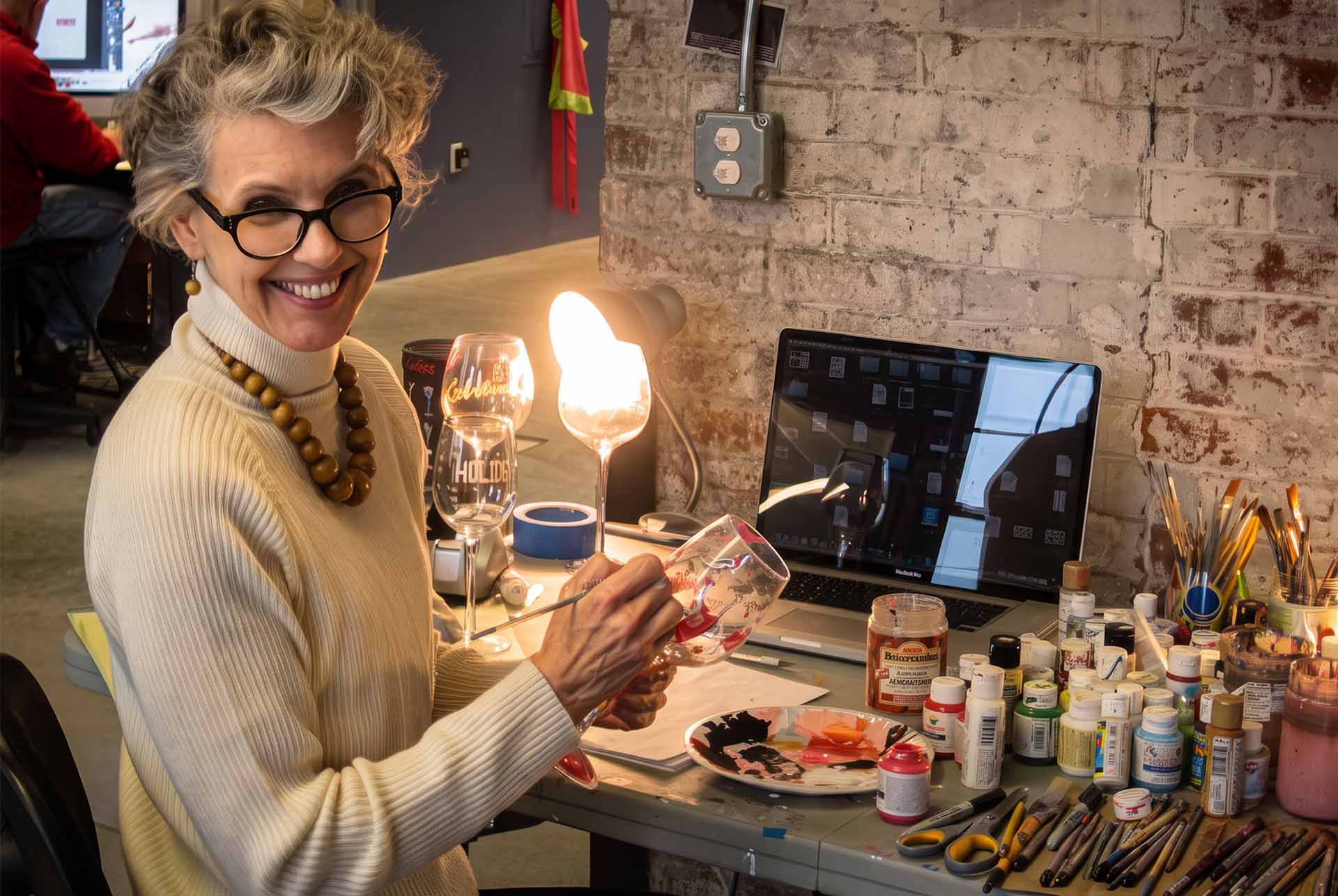 A Designs by Lolita fine artist hand-painting a glass at the studio