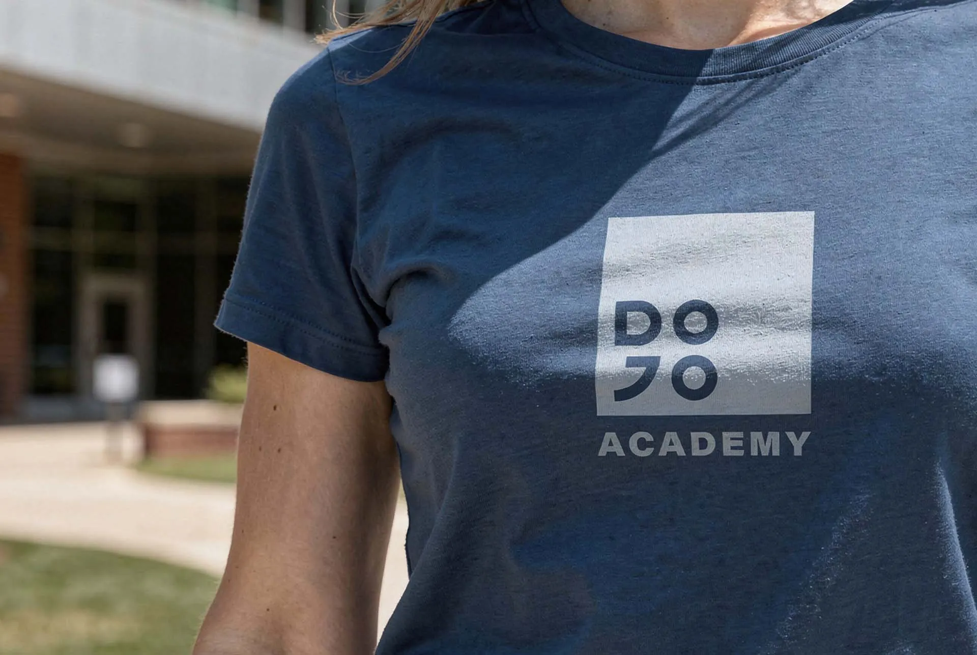 A woman wearing a navy Dojo Academy tee