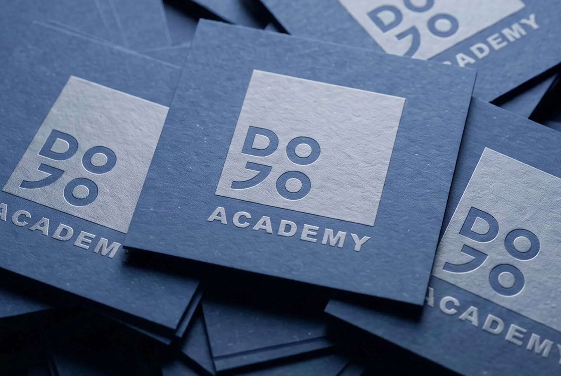 A stack of navy Dojo Academy printed folders
