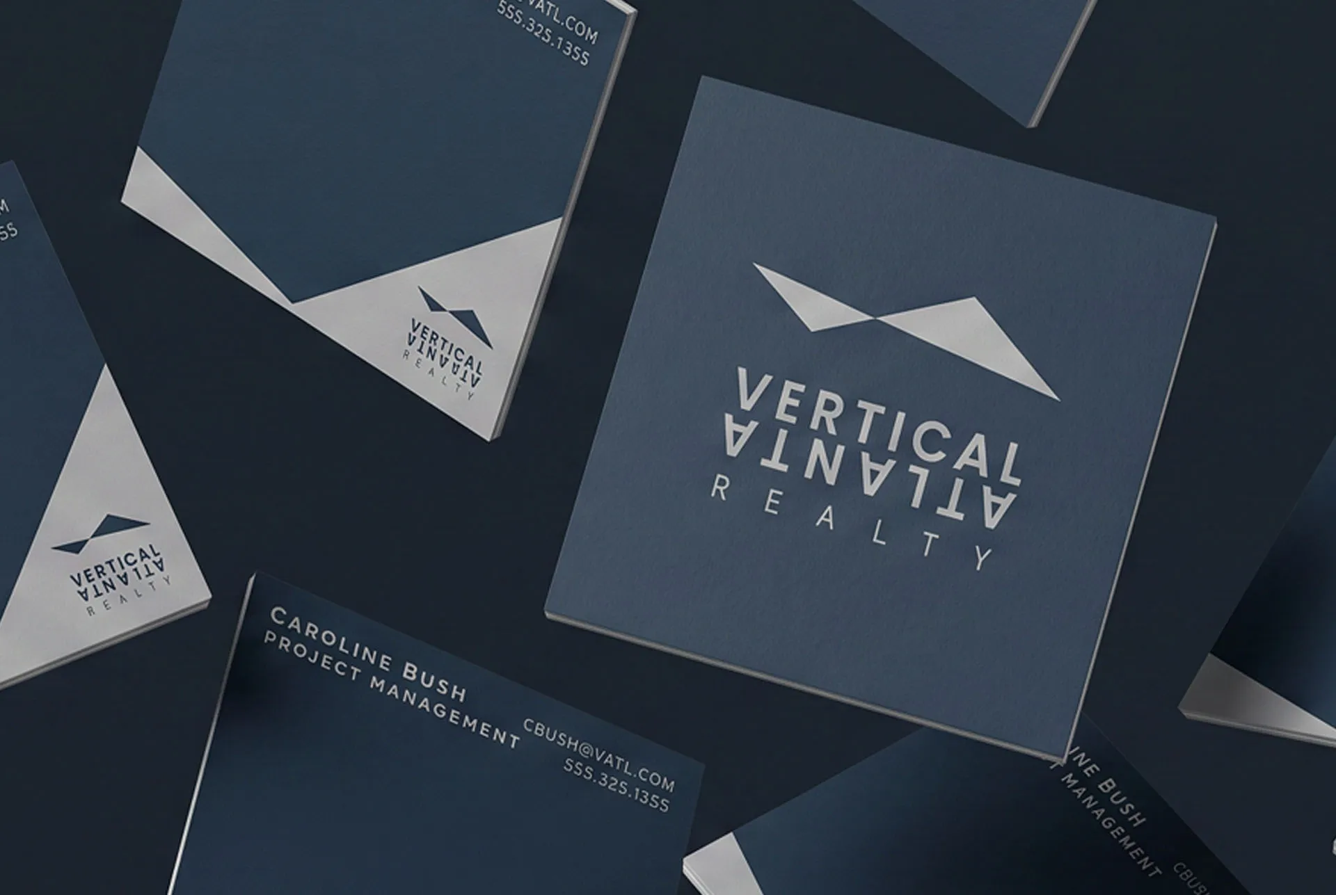 Vertical Atlanta business cards and folders scattered across a dark surface