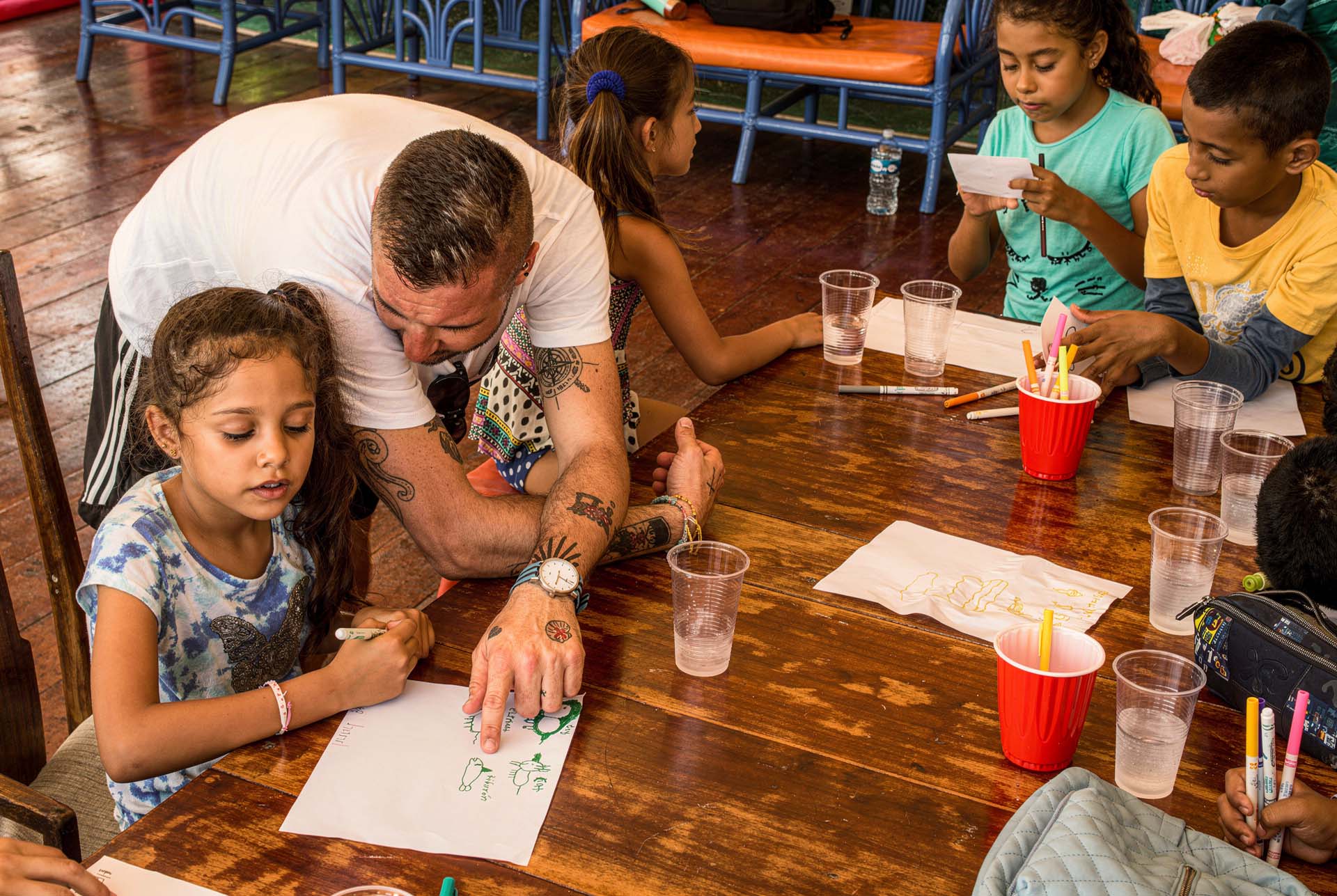 Andrew McKee drawing with kids at the Helping Hands Nicaragua art program