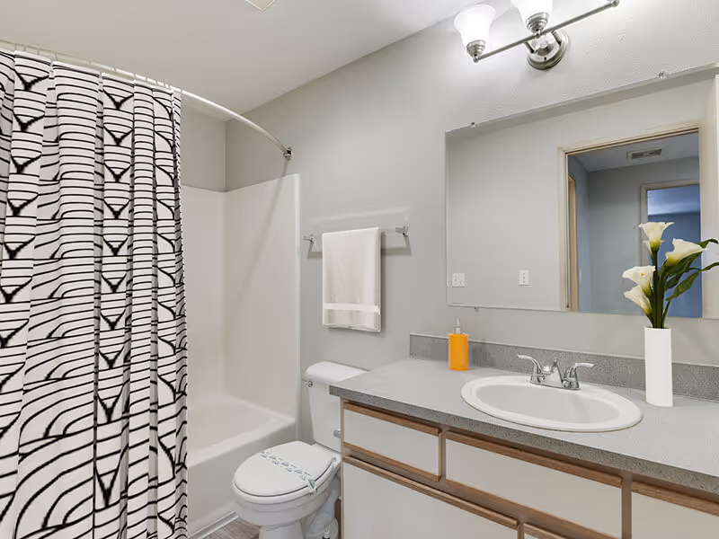 Bathroom with white cabinets and shower tub combo virtually staged