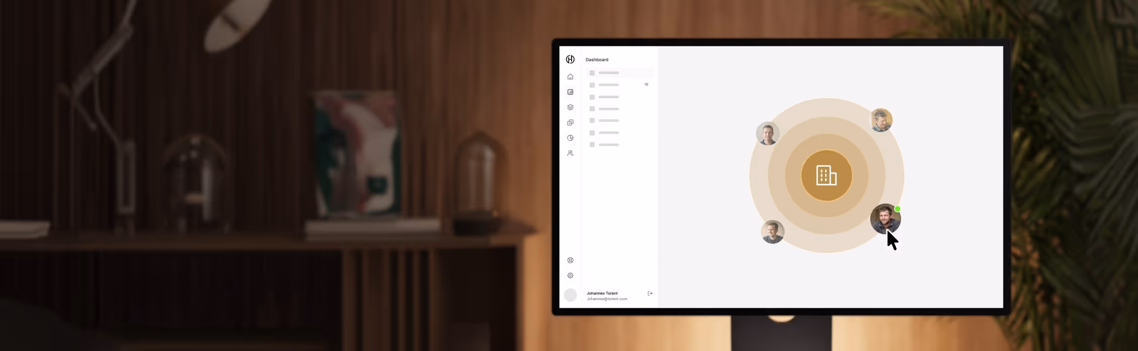 Computerbildschirm zeigt ein Dashboard mit einem zentralen Gebäude-Symbol und vier Benutzerprofilbildern.