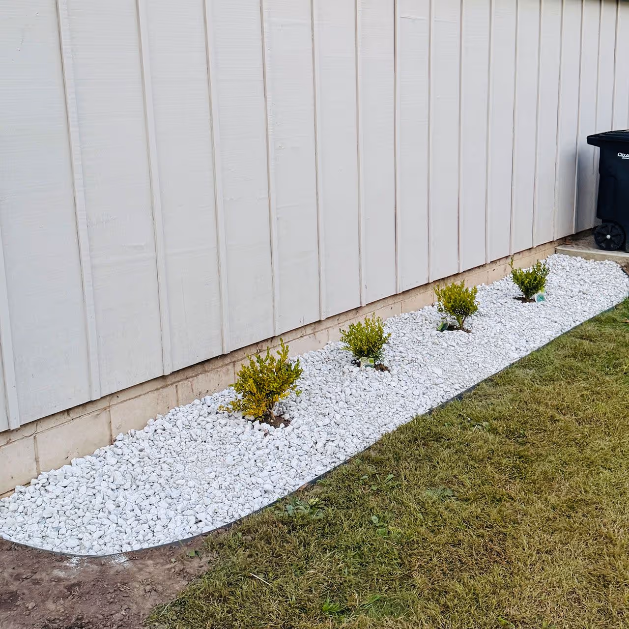 Landscaping installation with decorative stone and plant layout